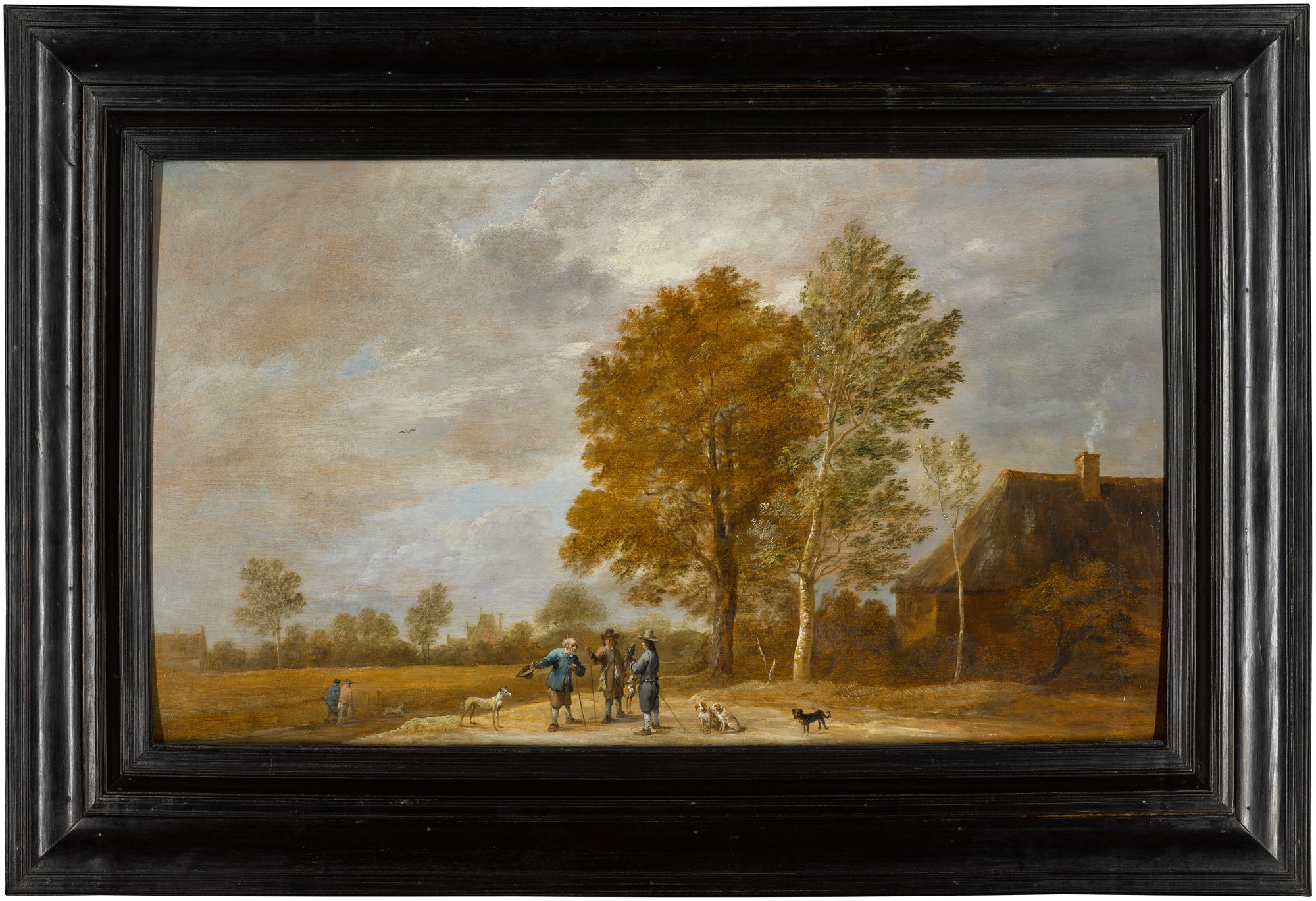 A landscape with a falconer and other figures conversing, with dogs