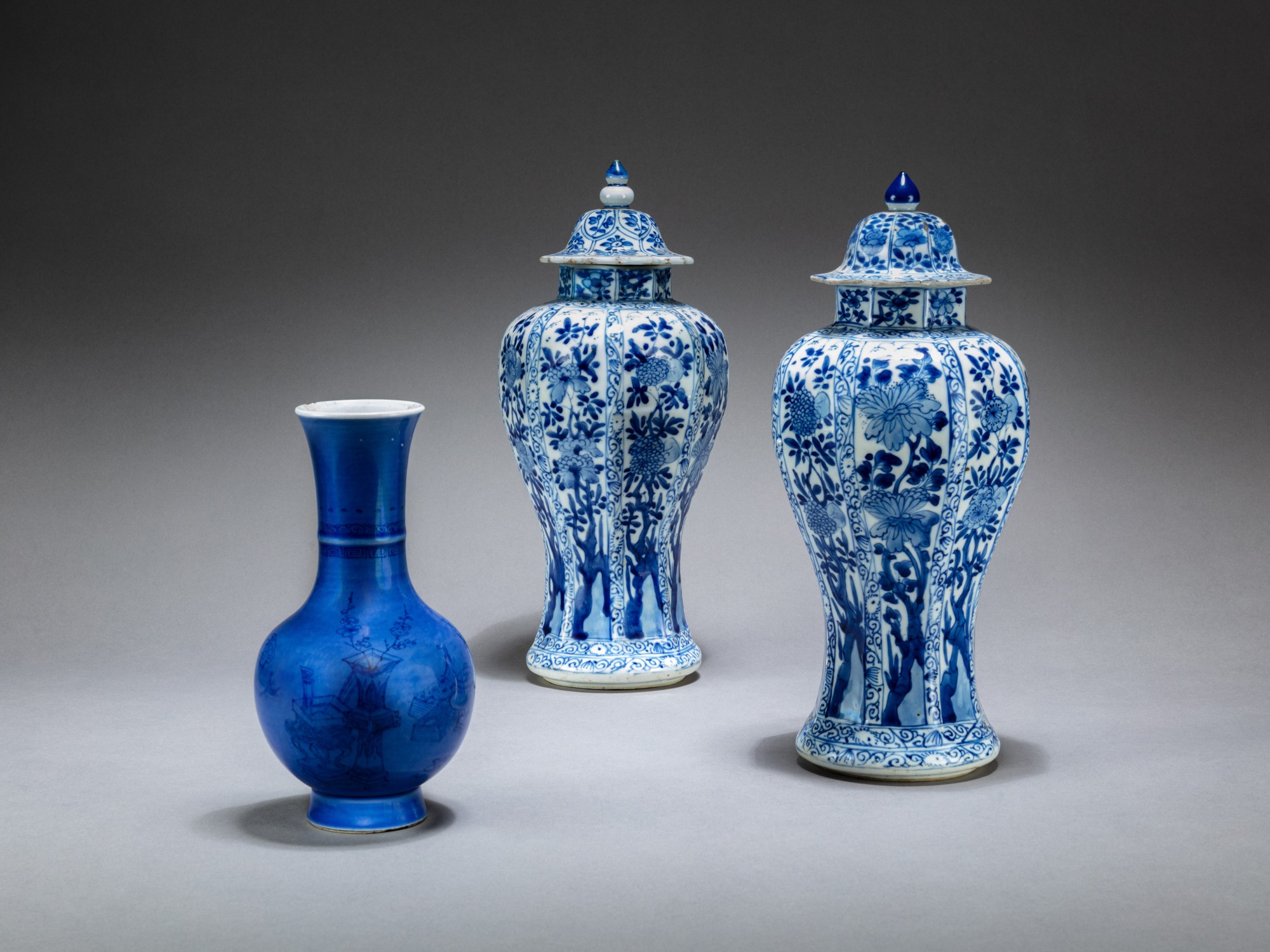 Two blue and white octagonal baluster vases and covers and a powder