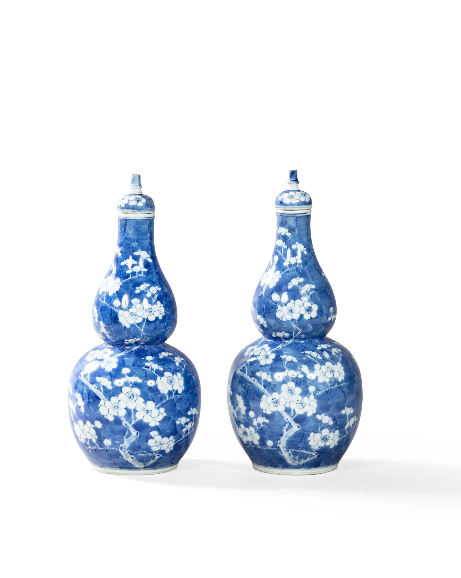a-pair-of-blue-and-white-double-gourd-prunus-vases-and-covers-china