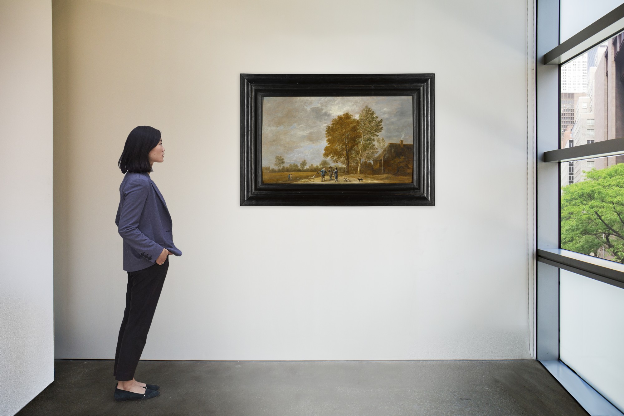 A landscape with a falconer and other figures conversing, with dogs