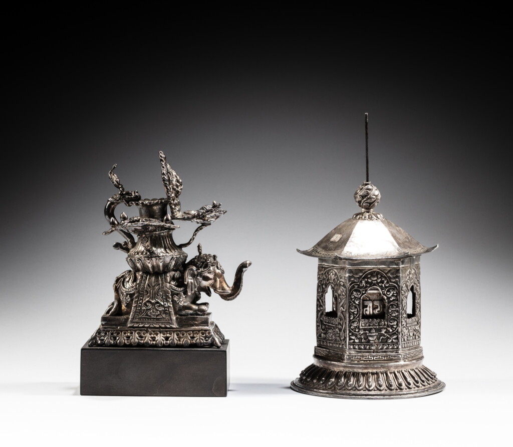 View full screen - View 1 of Lot 27. A silver table prayer wheel and a metal 'elephant' oil lamp, Nepal, 20th century | 尼泊爾 二十世紀 銀轉經筒及鐵象紋油燈一組兩件.