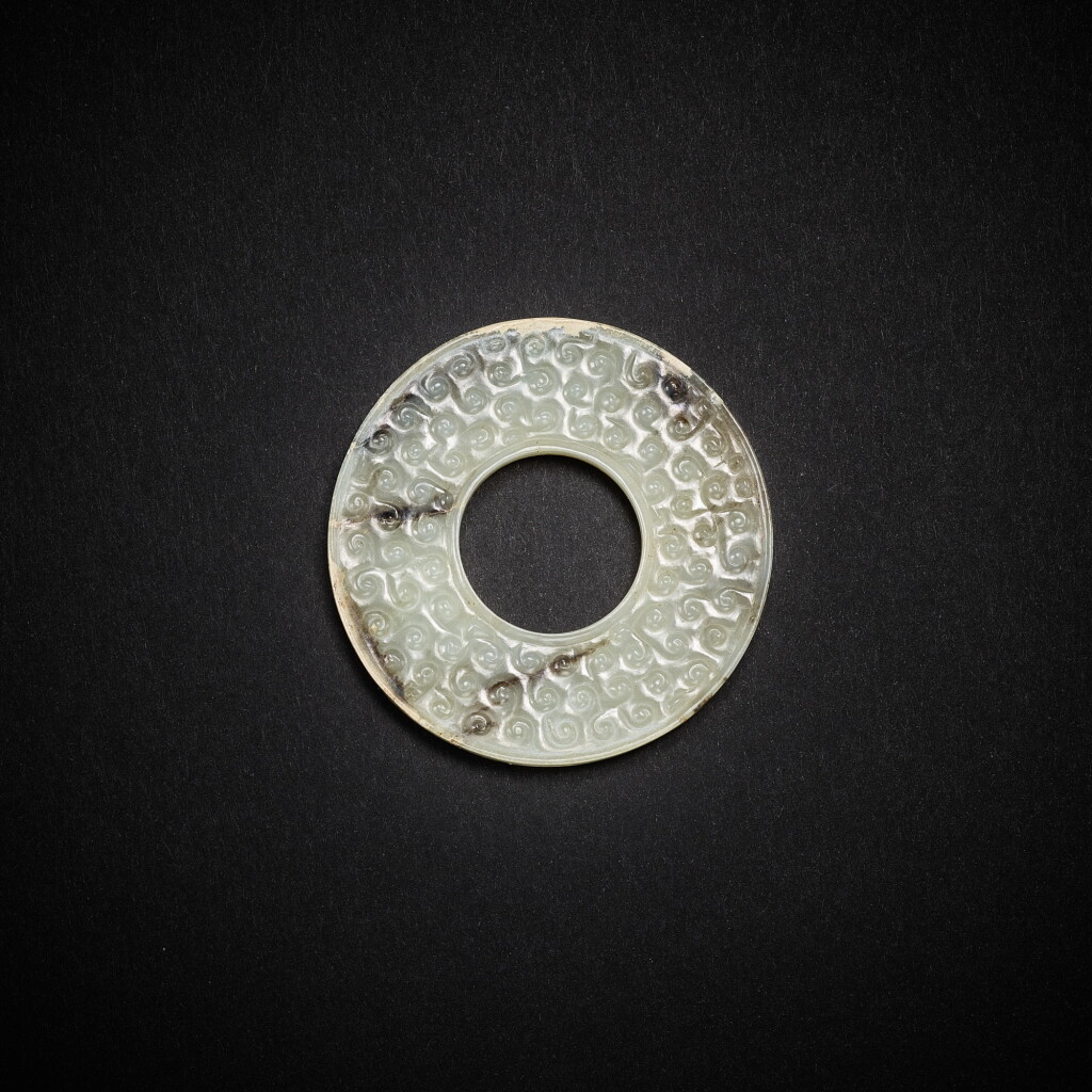 View full screen - View 1 of Lot 3819. A greyish-white jade disc, huan, Eastern Zhou dynasty, early - mid Warring States period- | 東周戰國早中期 灰白玉渦紋環.