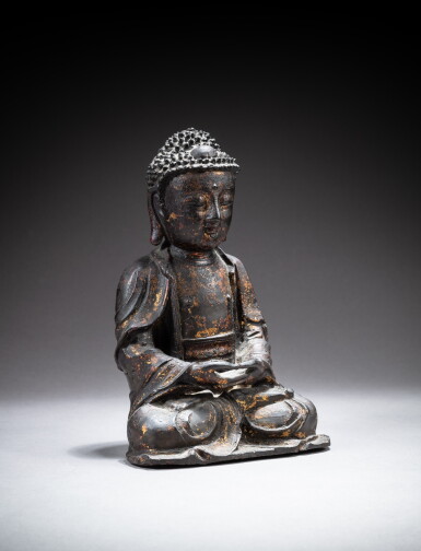 View full screen - View 1 of Lot 129. A gilt-lacquer bronze figure of Shakyamuni Buddha, Qing dynasty, 17th-18th century | 清十七至十八世紀 漆金銅釋迦牟尼佛坐像 .