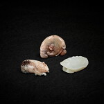 A white jade turtle shell, a celadon jade 'elephant' pendant, and a pale celadon jade bear, Ming dynasty or earlier 明或更早 白玉龜甲、青玉瑞象珮、及青白玉臥熊