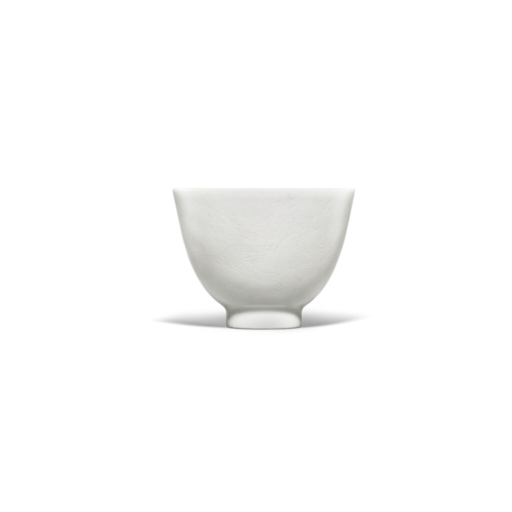 View full screen - View 1 of Lot 210. A small white-glazed anhua-decorated 'dragon' wine cup, Mark and period of Yongzheng.