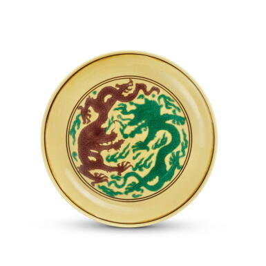 View full screen - View 1 of Lot 866. A yellow-ground green- and aubergine-enameled 'dragon' dish, Mark and period of Kangxi | 清康熙 黃地紫綠彩雙龍戲珠紋小盤 《大清康熙年製》款.
