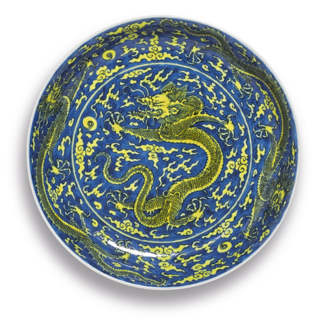 View full screen - View 1 of Lot 561. A FINE YELLOW-ENAMELED AND BLUE-GROUND 'DRAGON' DISH, KANGXI MARK AND PERIOD.
