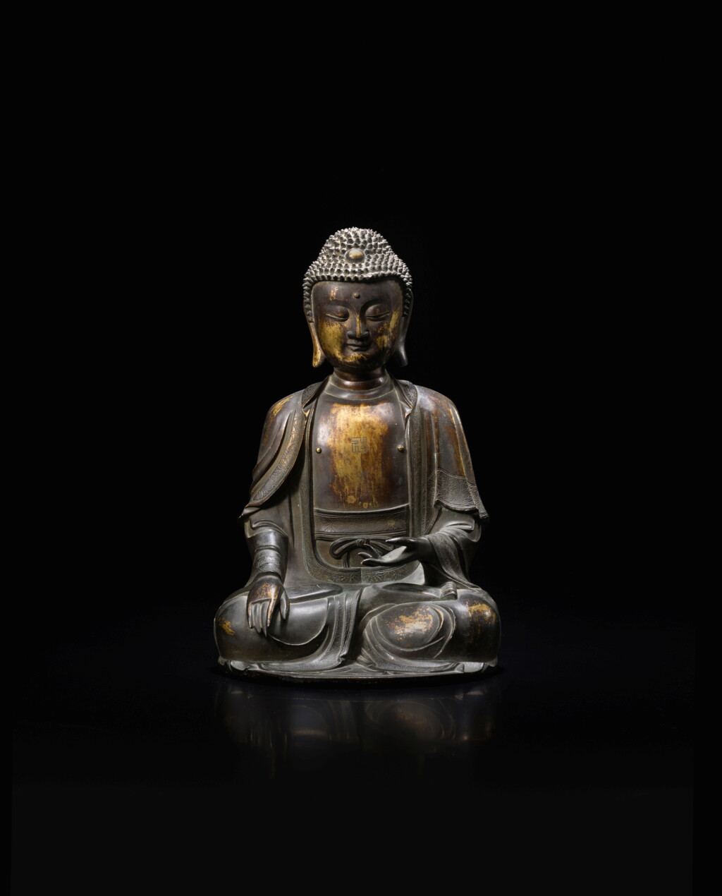 View full screen - View 1 of Lot 313. A parcel-gilt bronze figure of Shakyamuni Buddha, Ming dynasty, 16th/17th century | 明十七世紀 局部鎏金銅釋迦牟尼佛坐像.