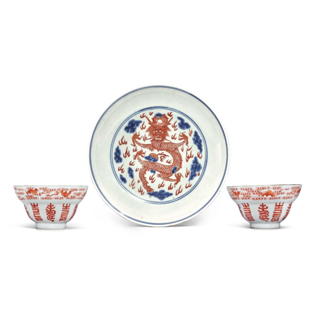View full screen - View 1 of Lot 1266. A pair of iron-red 'bat and shou' cups and an iron-red and underglaze-blue 'dragon' dish, 19th / 20th century | 十九 / 二十世紀 礬紅彩福壽雙全紋盃一對及青花礬紅彩雲龍紋盤.