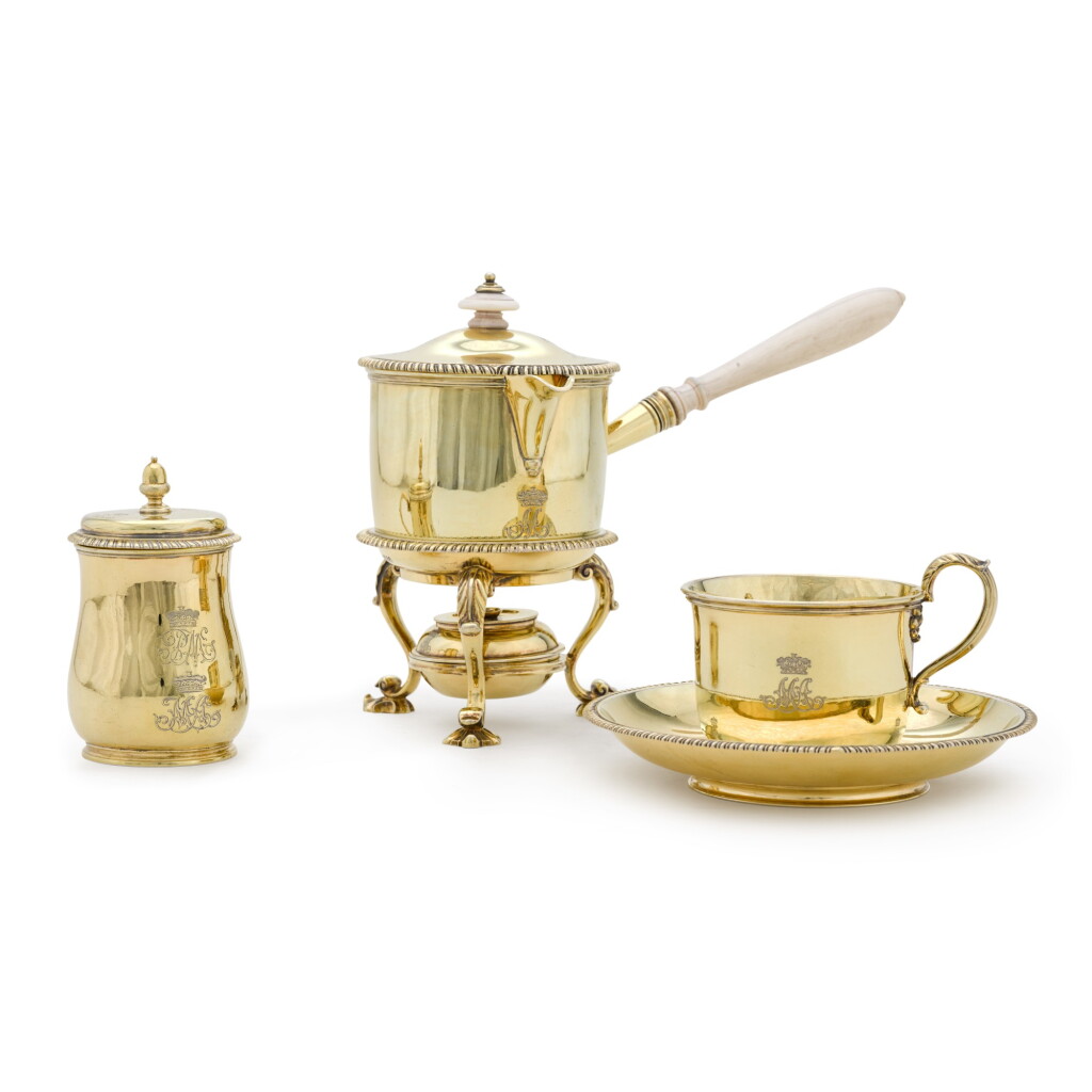 View full screen - View 1 of Lot 36. A George III and William IV silver-gilt part-christening set, the mug and cover Thomas Heming, London 1776; the cup and saucer and saucepan and stand Robert Garrard, London 1833.