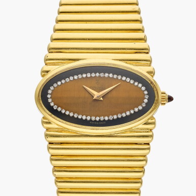 View full screen - View 1 of Lot 665. A yellow gold bracelet watch with tiger's eye, onyx and diamond-set dial, Circa 1970.