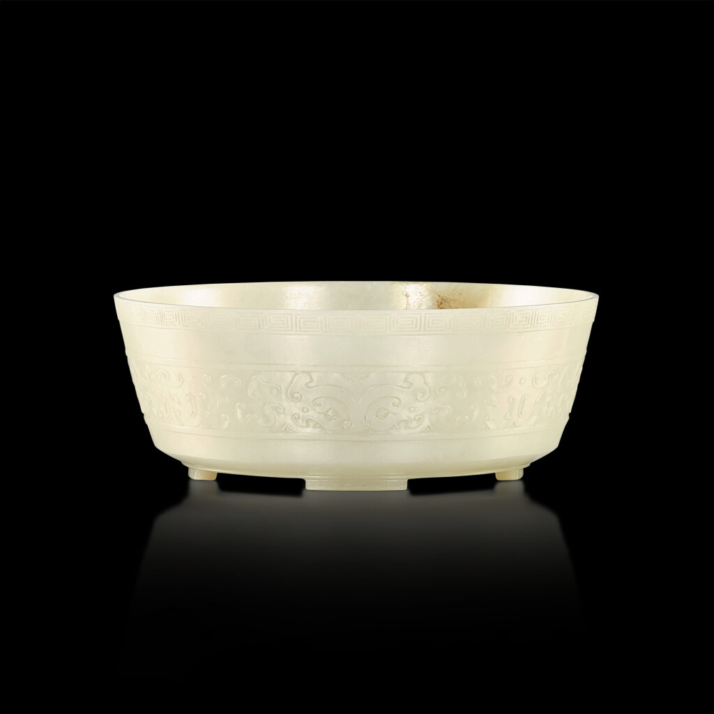 View full screen - View 1 of Lot 384. An imperial pale celadon and russet jade 'taotie' bowl, Qing dynasty, 18th century 清十八世紀 御製青白玉饕餮紋四足盌.