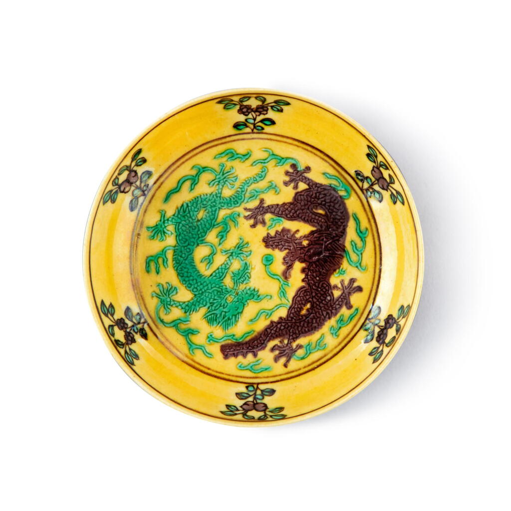 View full screen - View 1 of Lot 901. A small yellow-ground green- and aubergine-enameled 'dragon' dish, Seal mark and period of Daoguang | 清道光 黃地紫綠彩雙龍戲珠紋小盤 《大清道光年製》款.