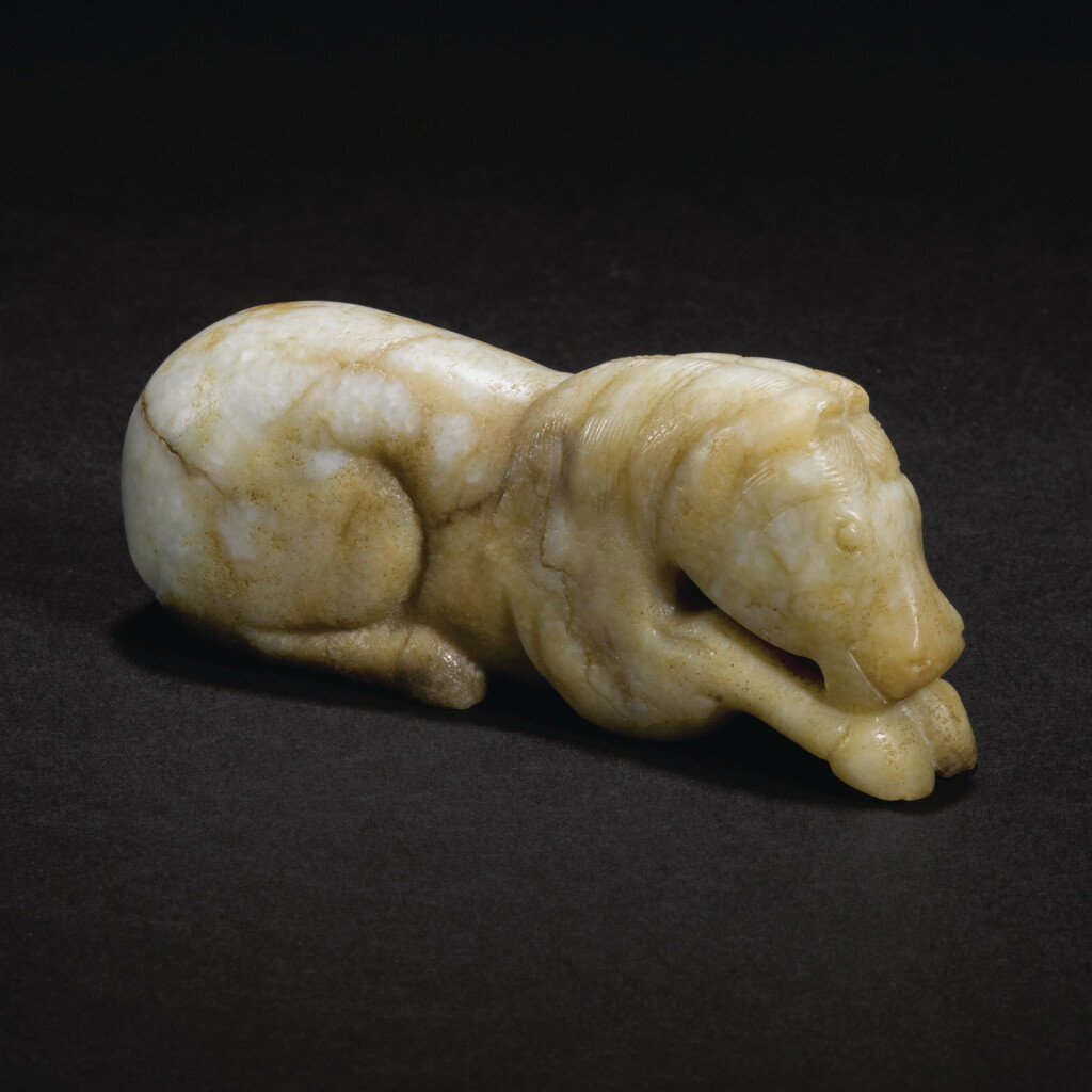 View full screen - View 1 of Lot 144. A MOTTLED JADE FIGURE OF A RECUMBENT HORSE, YUAN DYNASTY | 元 玉馬.