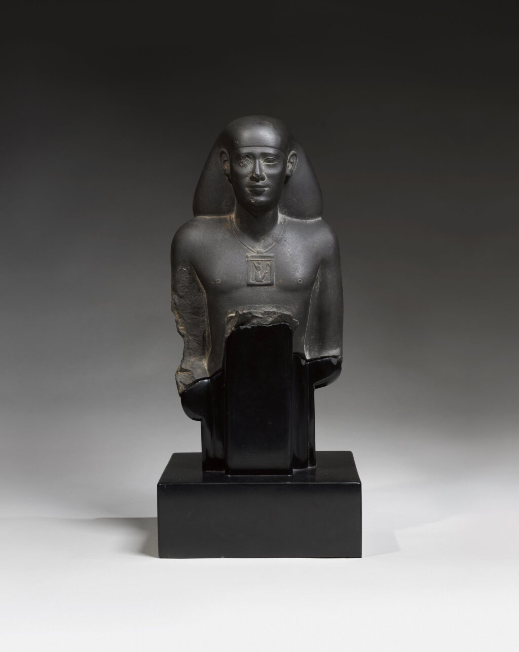 View full screen - View 1 of Lot 17. An Egyptian Greywacke Naophorous Bust of an Official, 2nd half of the 26th Dynasty, circa 600-525 B.C..