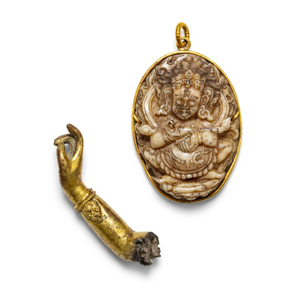 View full screen - View 1 of Lot 43. Médaillon de Mahakala en os sculpté et un bras de divinité en alliage de cuivre doré Tibet, XVIIIE-XIXE siècle | 西藏 十八至十九世紀 骨雕佛牌 及 鎏金銅合金佛像手臂殘件 | A carved bone medallion of Mahakala and a gilt copper-alloy arm of a divinity, Tibet, 18th-19th century.