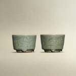 A pair of Longquan celadon-glazed incised 'floral' incense burners, Ming dynasty | 明 龍泉青釉劃花卷草紋筒式爐一對