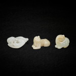 A group of three white jade and celadon jade 'feline' groups, Ming - Qing dynasty, 18th century 明至清十九世紀 白玉及青玉瑞獸一組三件