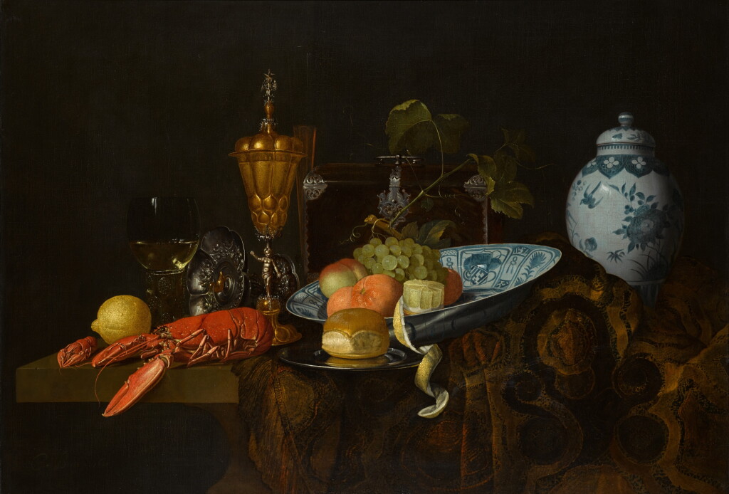 View full screen - View 1 of Lot 438. A 'pronk' still life with a lobster, bread, lemons, grapes and apricots alongside a gilt cup, tazza and an imported Chinese dish and jar.