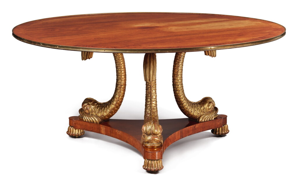 View full screen - View 1 of Lot 213. A REGENCY STYLE ROSEWOOD CIRCULAR DINING TABLE ON GILTWOOD DOLPHIN SUPPORTS, SECOND HALF 20TH CENTURY.