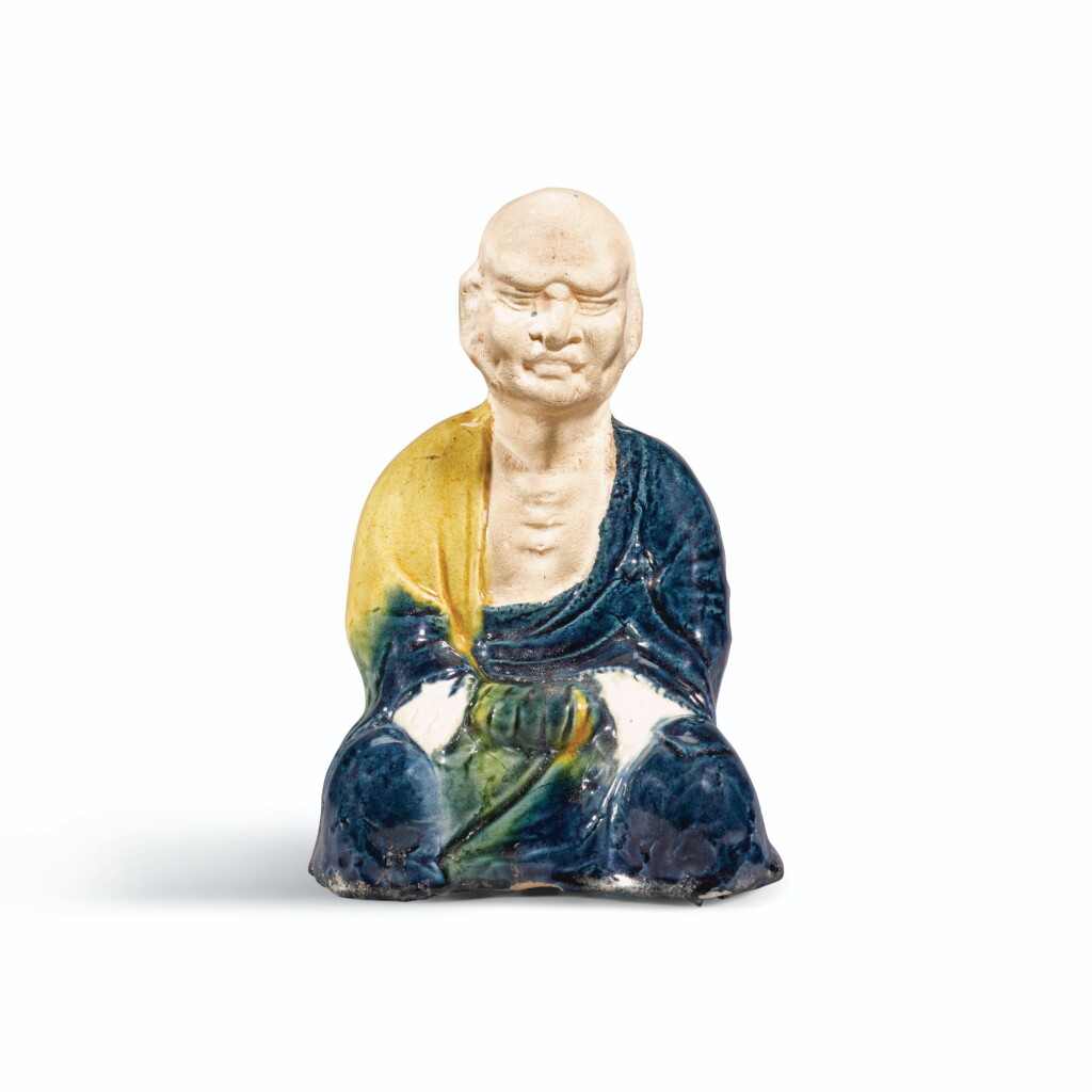 View full screen - View 1 of Lot 215. A RARE BLUE AND AMBER-GLAZED SEATED FIGURE OF A LUOHAN, TANG DYNASTY | 唐 藍釉羅漢坐像.