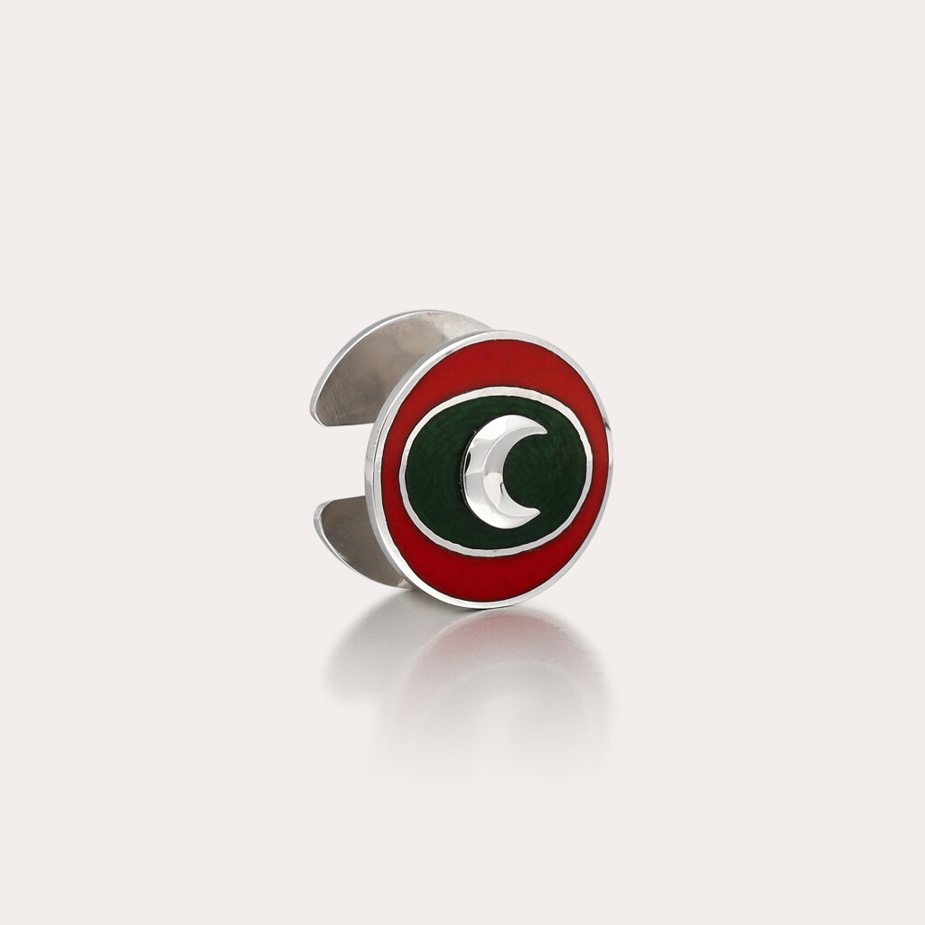View full screen - View 1 of Lot 398. A white gold and enamel lapel pin depicting a crescent moon with the colours of the Standard of the Sultan of Oman made for H.M. Qaboos bin Said | Circa 1975.