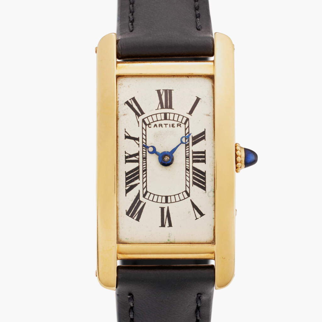 View full screen - View 1 of Lot 106. Tank Cintrée | A yellow gold curved rectangular wristwatch with gold deployant buckle, Circa 1926.