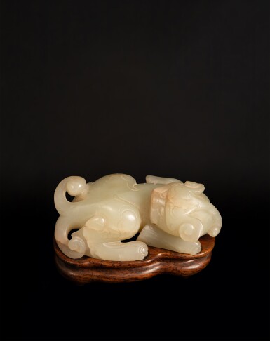 View full screen - View 1 of Lot 100. A celadon jade carving of a bixie, Ming dynasty | 明 青白玉雕辟邪把件.