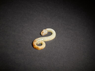 View full screen - View 1 of Lot 1. A celadon and russet jade snake, Eastern Zhou dynasty, Warring States period.