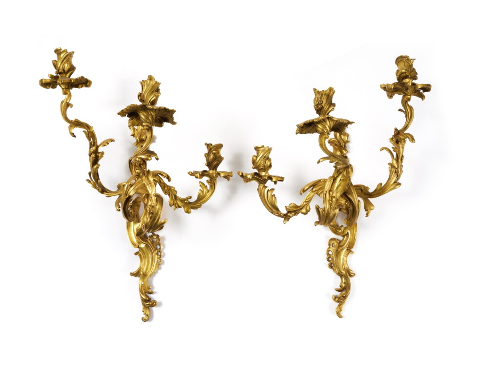 View full screen - View 1 of Lot 24. A Near Pair of Louis XV Gilt-Bronze Three-Branch Wall Lights, Mid-18th Century.