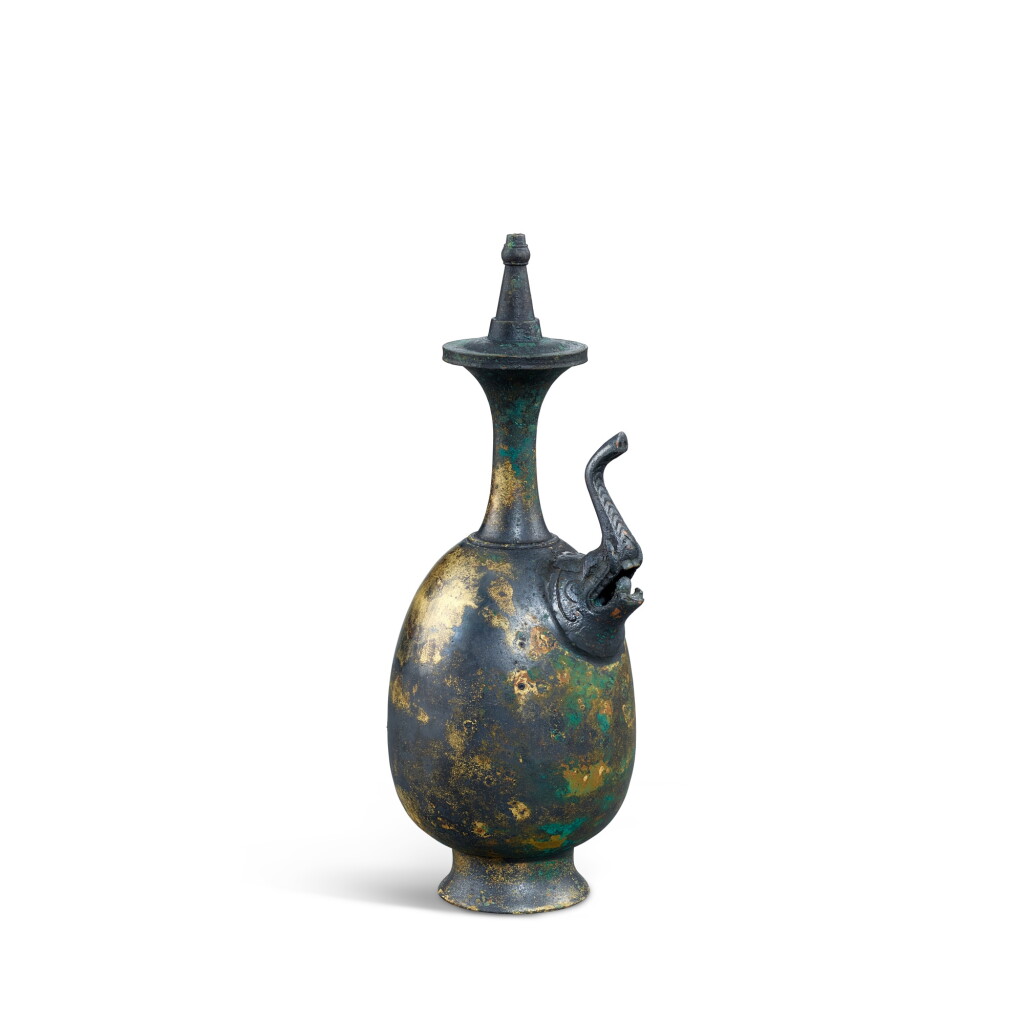 View full screen - View 1 of Lot 3605. A gilt-bronze 'elephant' Buddhist ewer and cover, Tang dynasty | 唐 銅鎏金象首淨瓶.