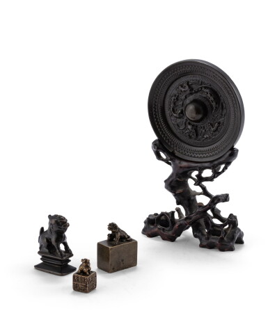 View full screen - View 1 of Lot 76. Miroir archaïsant en bronze patiné sur socle en bois et trois petits cachets en bronze patiné Dynasties Ming et Qing | 明及清 銅鏡 及 銅印章一組三件 | A bronze archaistic mirror and three small bronze seals, Ming and Qing Dynasties .