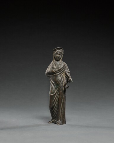 View full screen - View 1 of Lot 9. Etruscan Bronze Figure of a Goddess or Votary holding a Serpent, circa 3rd Century B.C..