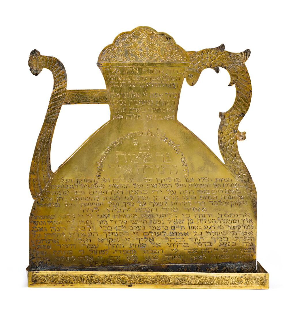 View full screen - View 1 of Lot 139. A NEAR EASTERN BRASS HANUKAH LAMP WITH EWER-FORM BACKPLATE, EARLY 20TH CENTURY.