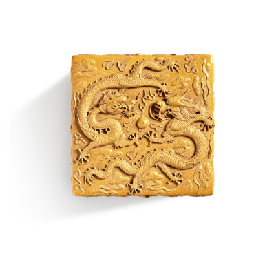 View full screen - View 1 of Lot 555. A carved yellow-glazed biscuit 'dragon' square box and cover, Mark and period of Guangxu | 清光緒 黃釉雕瓷雲龍戲珠紋方蓋盒 《大清光緒年製》款.