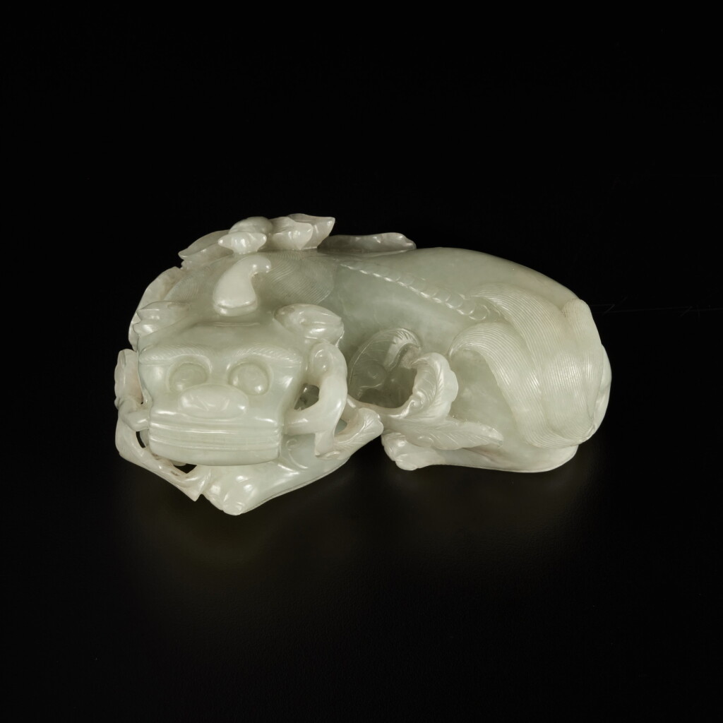 View full screen - View 1 of Lot 209. A pale celadon jade carving of a qilin, Qing dynasty, 19th century | 清十九世紀 青白玉雕麒麟銜蓮把件.
