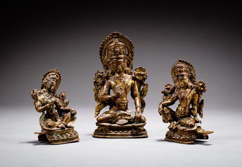 View full screen - View 1 of Lot 109. A gilt-copper alloy triad of Indra and consorts Nepal, 16th-17th century | 尼泊爾 十六至十七世紀 鎏金銅合金因陀羅坐像.