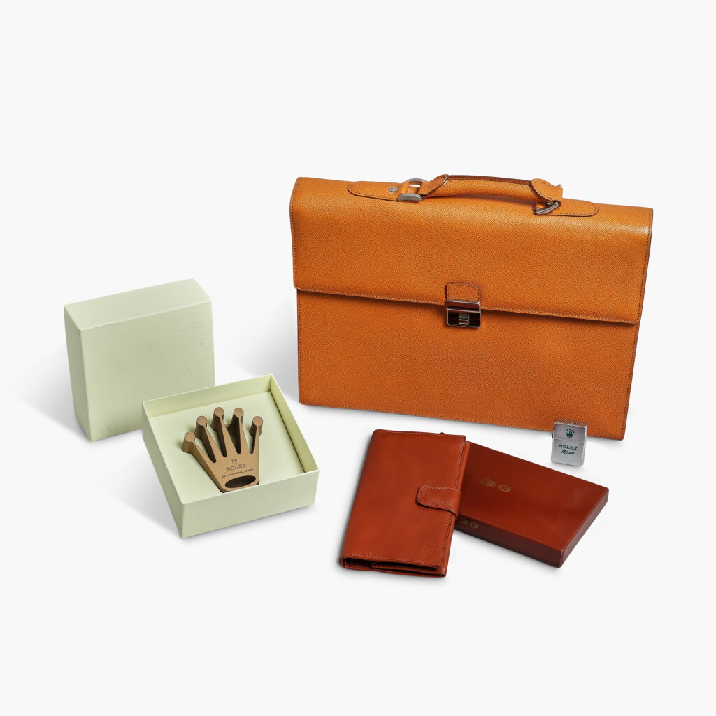 View full screen - View 1 of Lot 304. A group of accessories comprising a paperweight, lighter, wallet, and briefcase, circa 1990s–2000s.