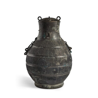 View full screen - View 1 of Lot 247. An archaic bronze wine vessel and cover (Hu), Eastern Zhou dynasty, Warring States period | 東周 戰國 青銅交龍紋牛首耳蓋壺.