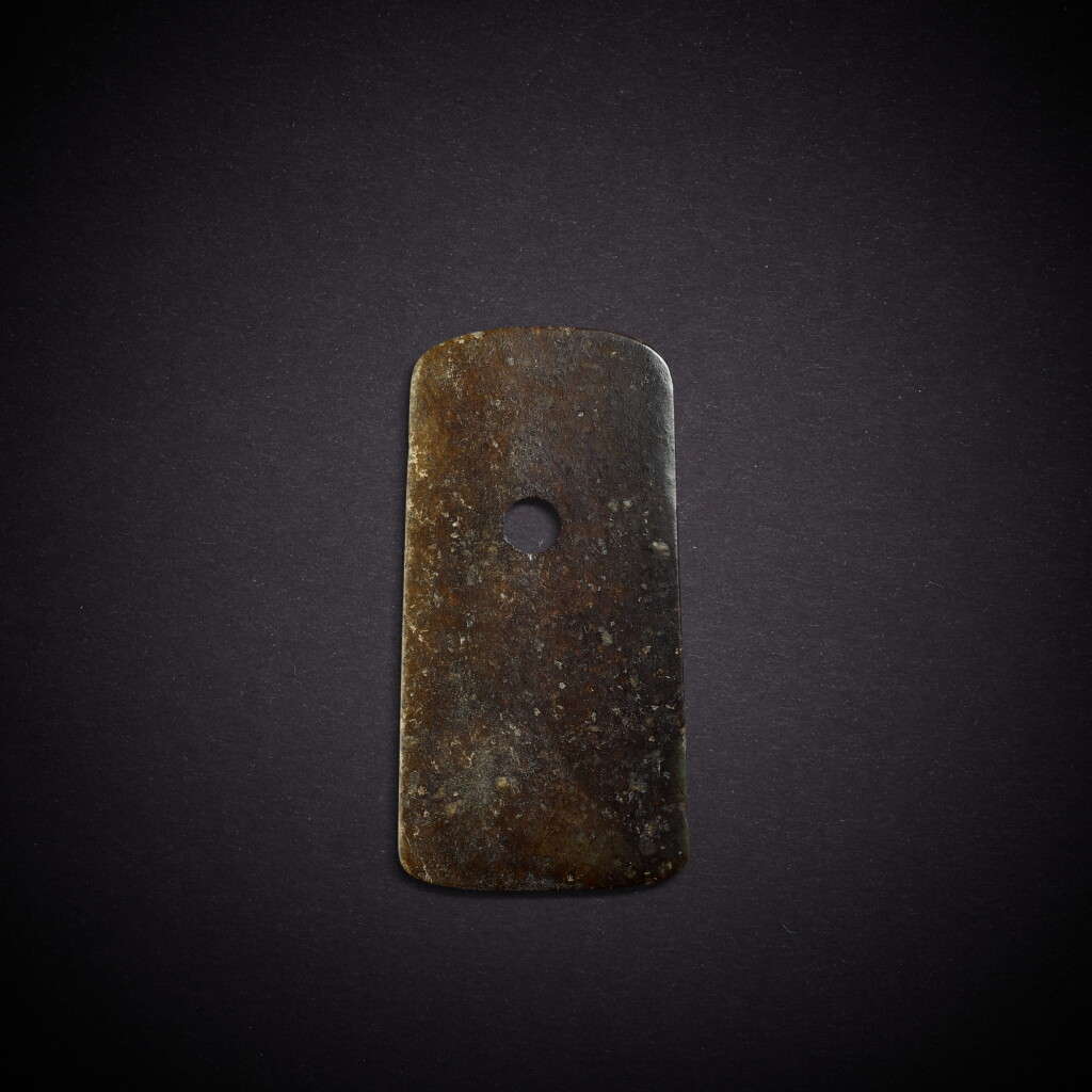 View full screen - View 1 of Lot 6802. A celadon and russet jade blade, yue, Neolithic period | 新石器時代 青玉鉞.