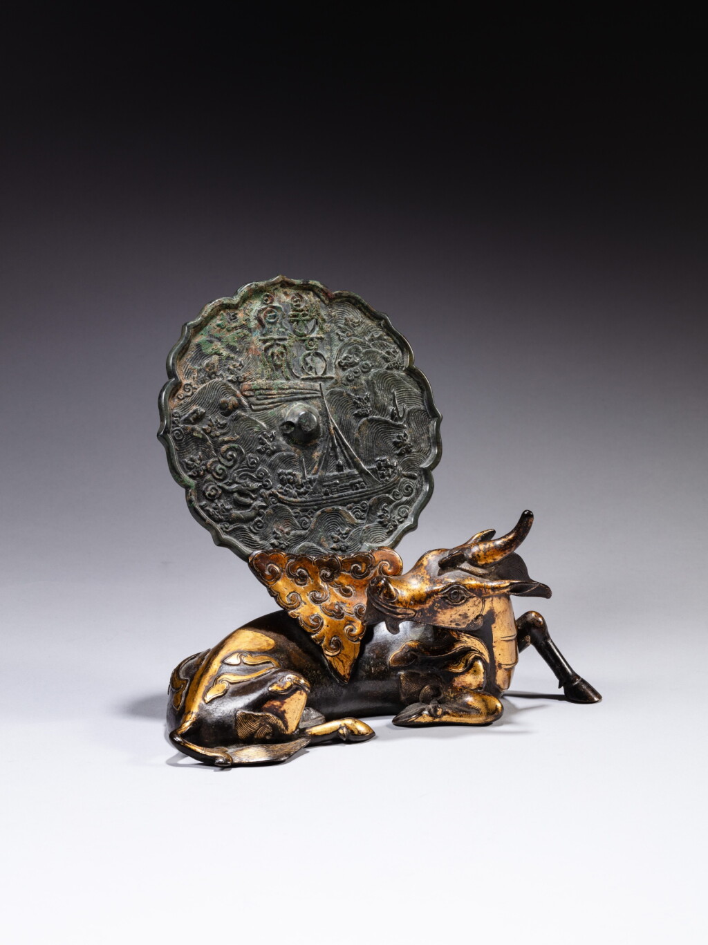 View full screen - View 1 of Lot 69. A parcel-gilt bronze 'xiniu' mirror stand and an archaic bronze mirror the stand, Ming dynasty, the mirror, 12th - 14th century | 明 銅局部鎏金犀牛望月鏡架 及 十二至十四世紀銅龍紋鏡.