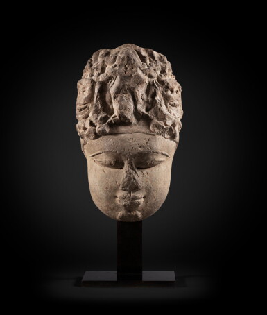 View full screen - View 1 of Lot 130. A rare monumental buff sandstone head of a Devi North India, 9th-10th century | 印度北 九至十世紀 砂岩雕提毗首.