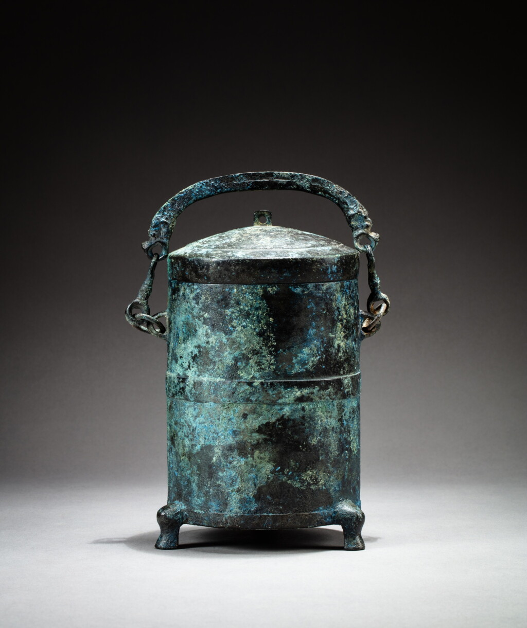 View full screen - View 1 of Lot 30. An archaic bronze cylindrical handled vessel and cover, zun, Han dynasty | 漢 青銅提梁三足蓋尊.