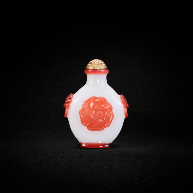 Voir en plein écran - Voir 1 du lot 987. An imperial red-overlay white glass 'musk-mallow' snuff bottle, Mark and period of Qianlong 清乾隆 御製白地套紅料蜀葵紋鋪首鼻煙壺 《乾隆年製》款.