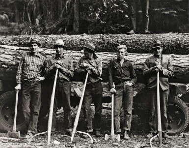 View full screen - View 1 of Lot 323. 5 Idaho farmers, members of the Ola Self Help Sawmill Co-op, in the woods standing against load of logs ready to go down to their mill about three miles away. Gem County, Idaho.