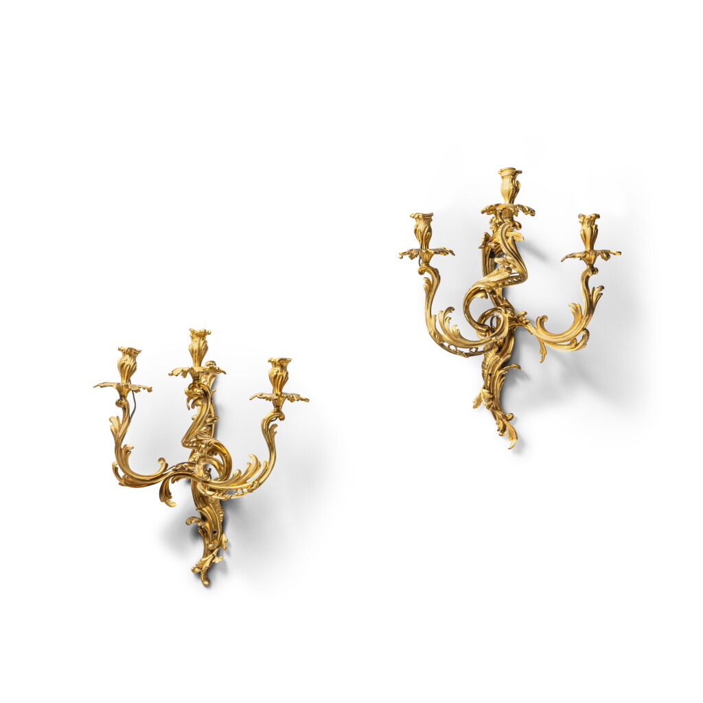View full screen - View 1 of Lot 291. A pair of Louis XV style gilt-bronze three-light wall lights, 19th century, in the style of Philippe Caffieri.