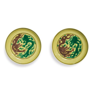 View full screen - View 1 of Lot 559. A PAIR OF GREEN AND AUBERGINE-ENAMELED YELLOW-GROUND 'DRAGON' DISHES, KANGXI MARKS AND PERIOD.