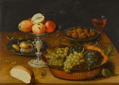 View full screen - View 1 of Lot 32. Still life of grapes in a dish, apples in a silver tazza and hazelnuts and medlars on pewter plates, on a wooden table.
