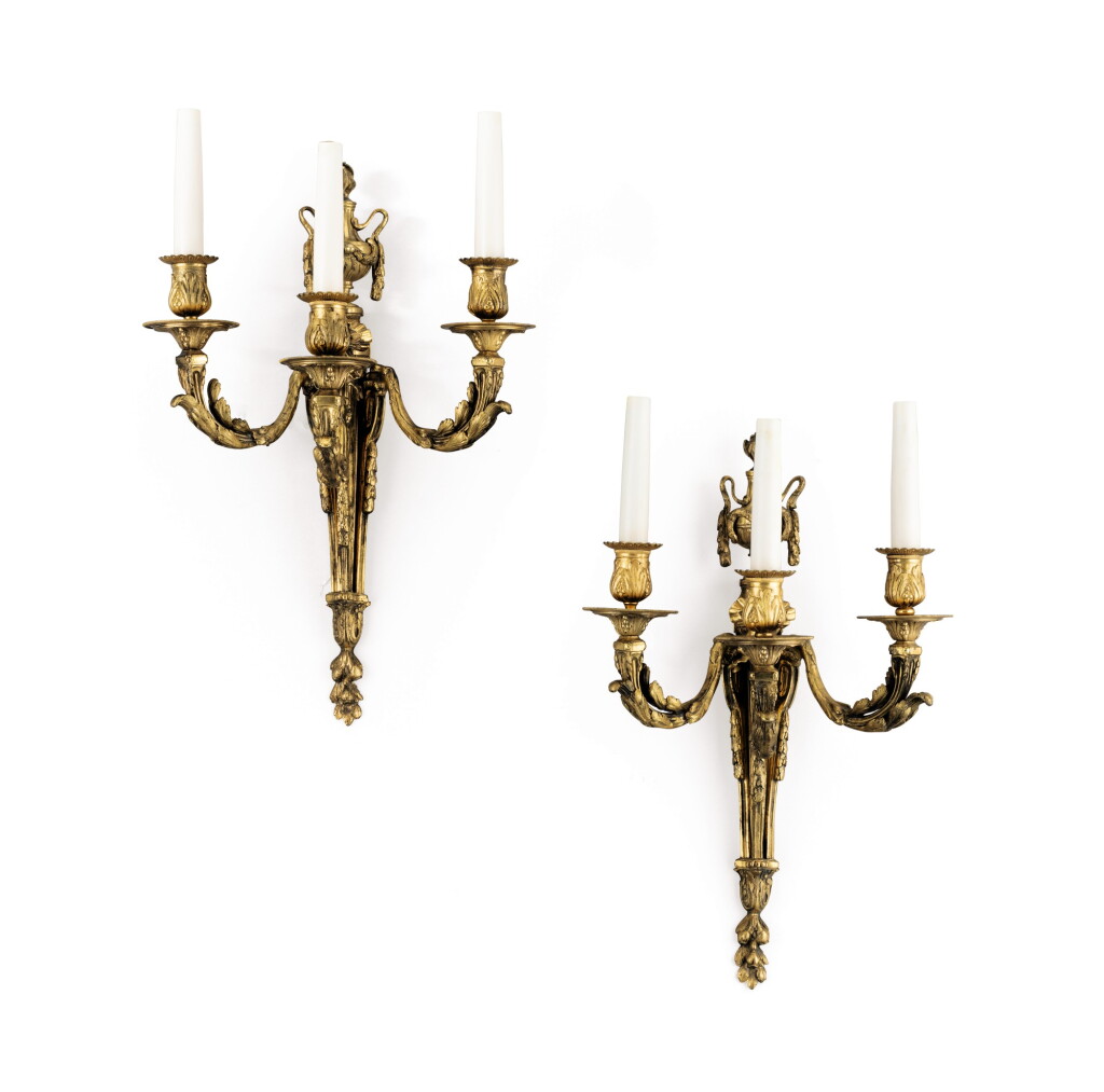 Voir en plein écran - Voir 1 du lot 123. A pair of Louis XVI style three-branch gilded brass wall lights,.