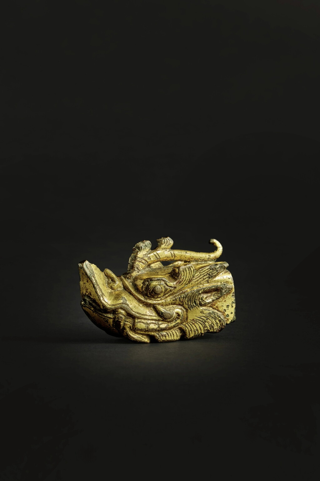 View full screen - View 1 of Lot 57. An exceedingly rare gilt-bronze dragon head-form fitting, Tang dynasty.